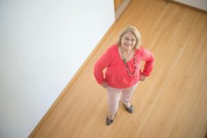 A senior woman standing in a house undertaking a flipping